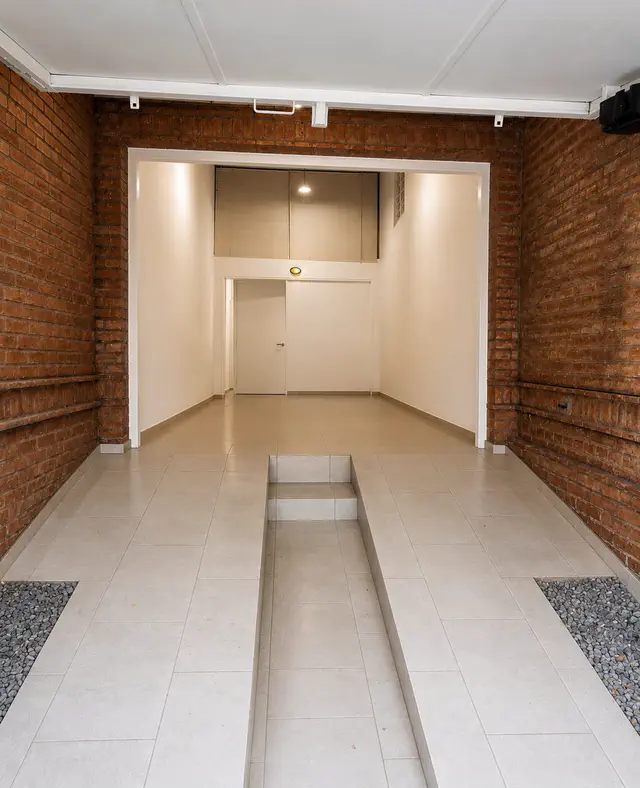 Garage cubierto con paredes de ladrillo visto y piso cerámico